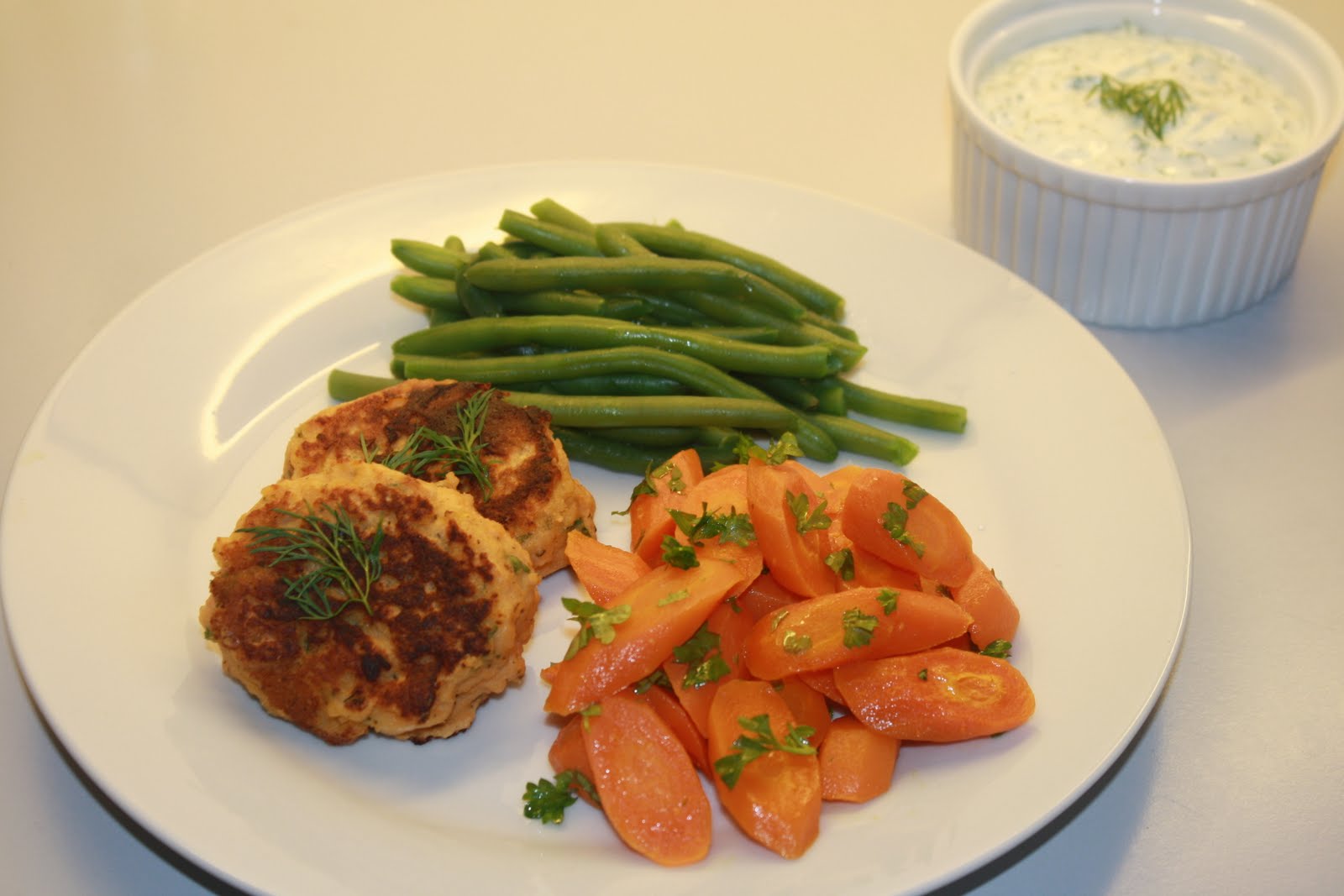 Laksefrikadeller med bagte gulerødder, grønne bønner og urtecreme