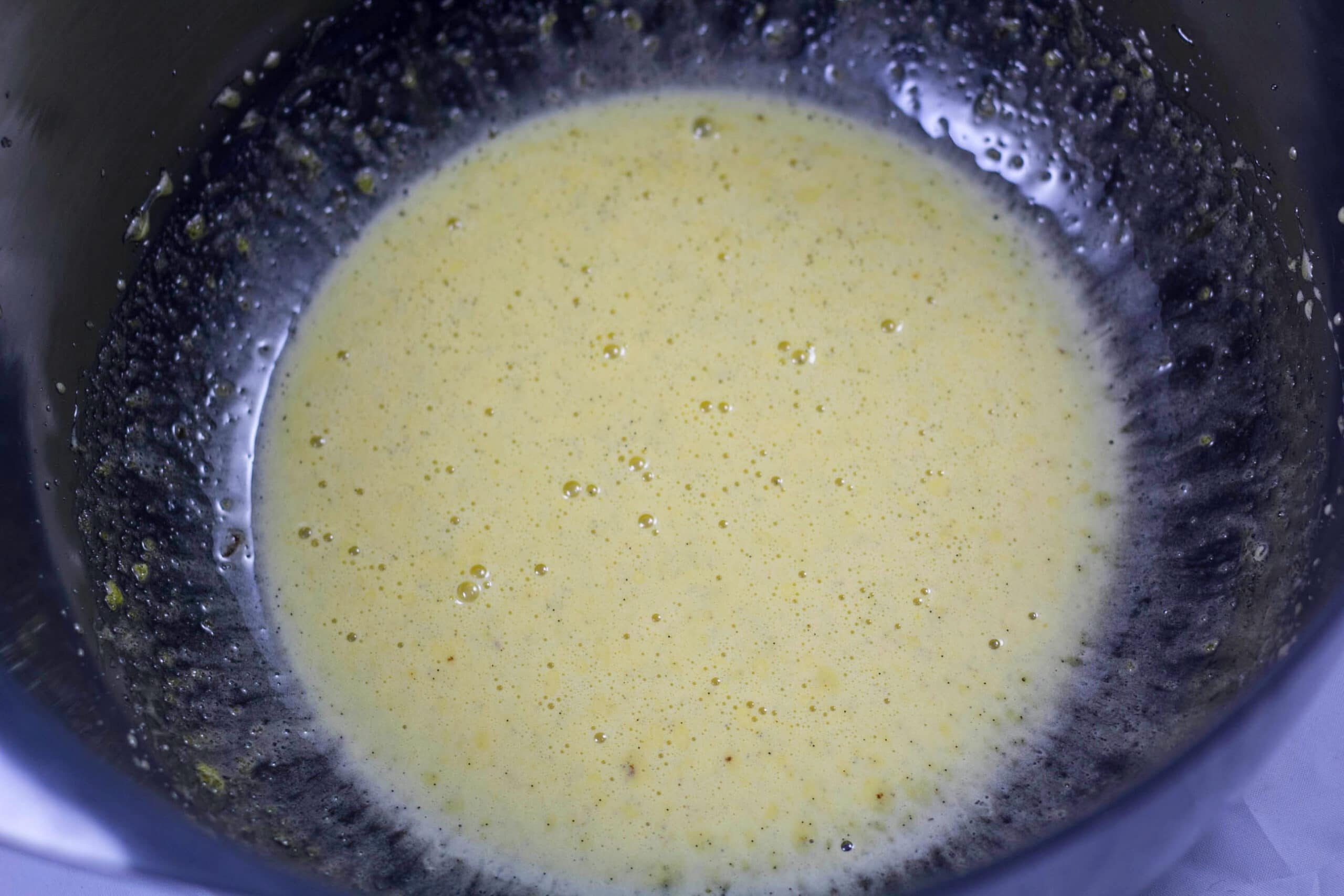 Æggeblommer, sukker og vanilje er pisket i skål