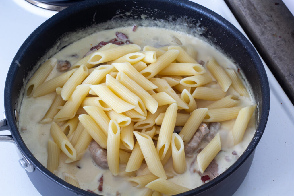 Pastaret med svinemørbrad og bacon i cremet hvidvinssauce ()