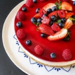 Cheesecake med hindbærgelé og pyntet med jordbær, hindbær og blåbær også kaldet ostekage