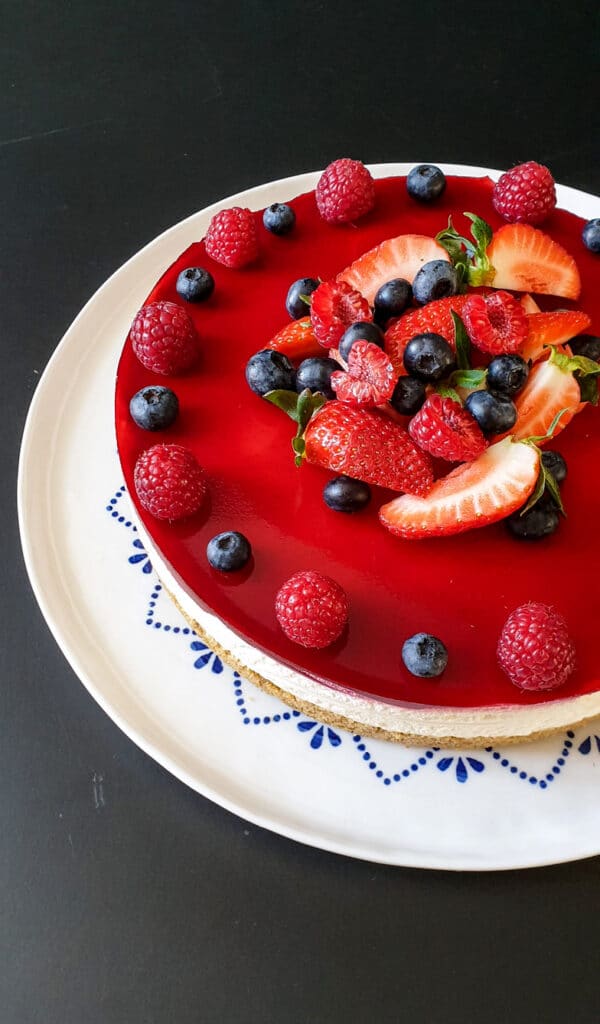 Cheesecake med hindbærgelé og pyntet med jordbær, hindbær og blåbær også kaldet ostekage