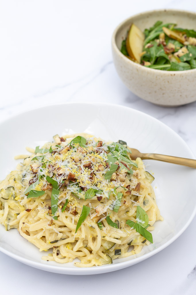 Vegetarisk pastaret med citron og squash serveret med pære-rucolasalat